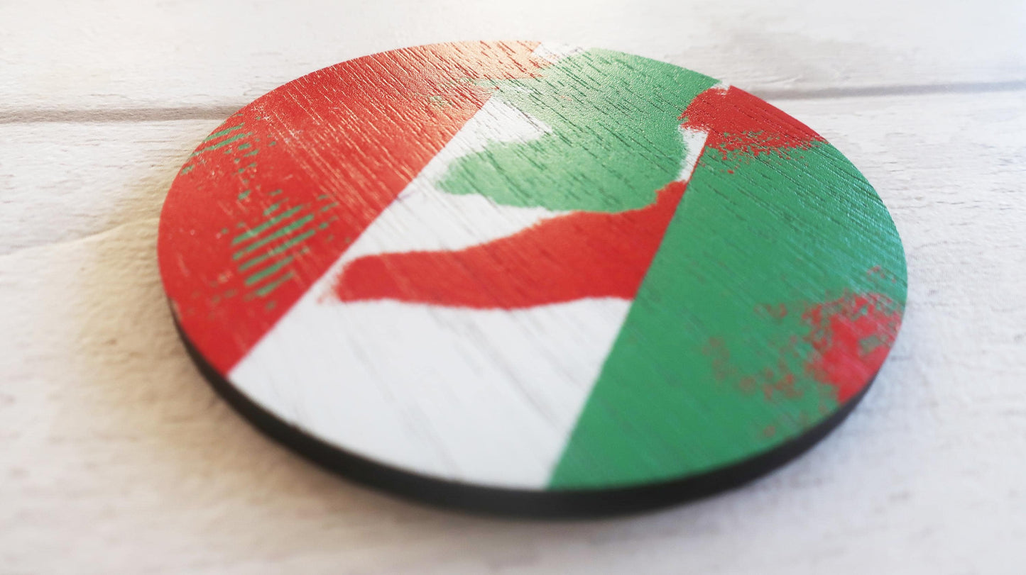 Round wooden brooch with a colorful design on a light wooden surface