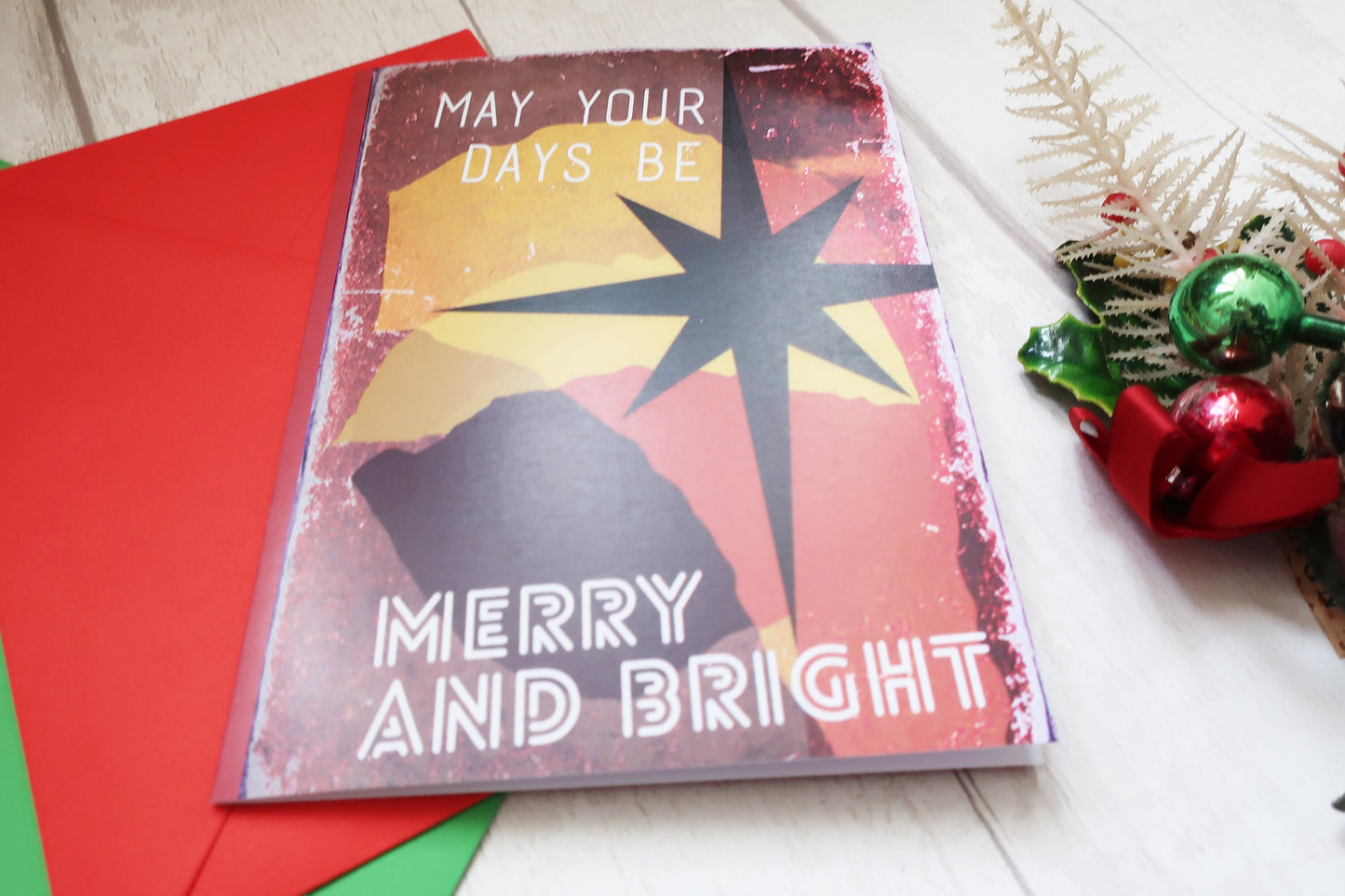 Christmas card with 'May your days be merry and bright' text on a red envelope.