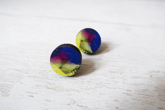 Multicolored round earrings on a light wooden surface