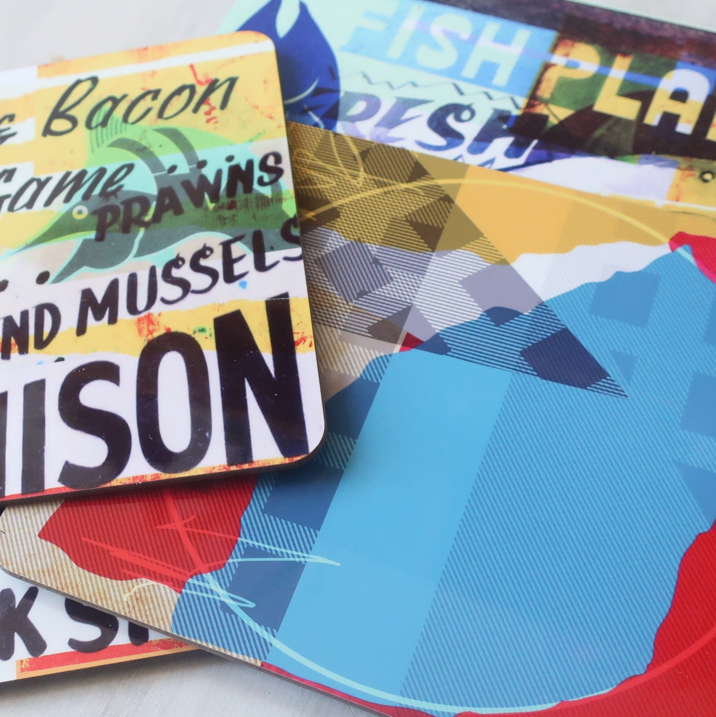 Colorful placemats with text and abstract designs on a white surface