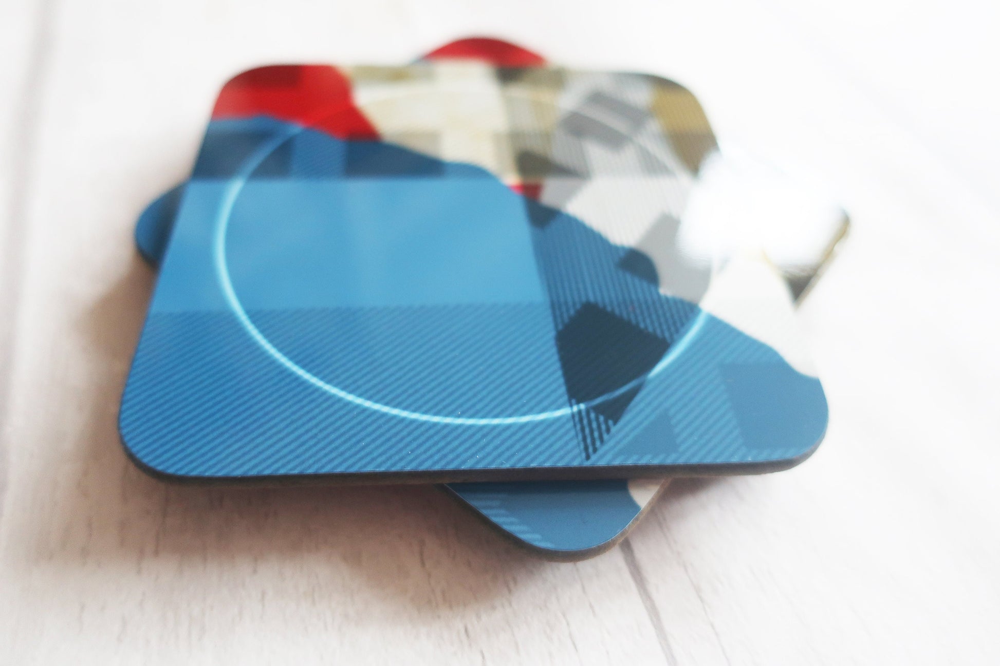 Stack of colorful coasters on a light wooden surface