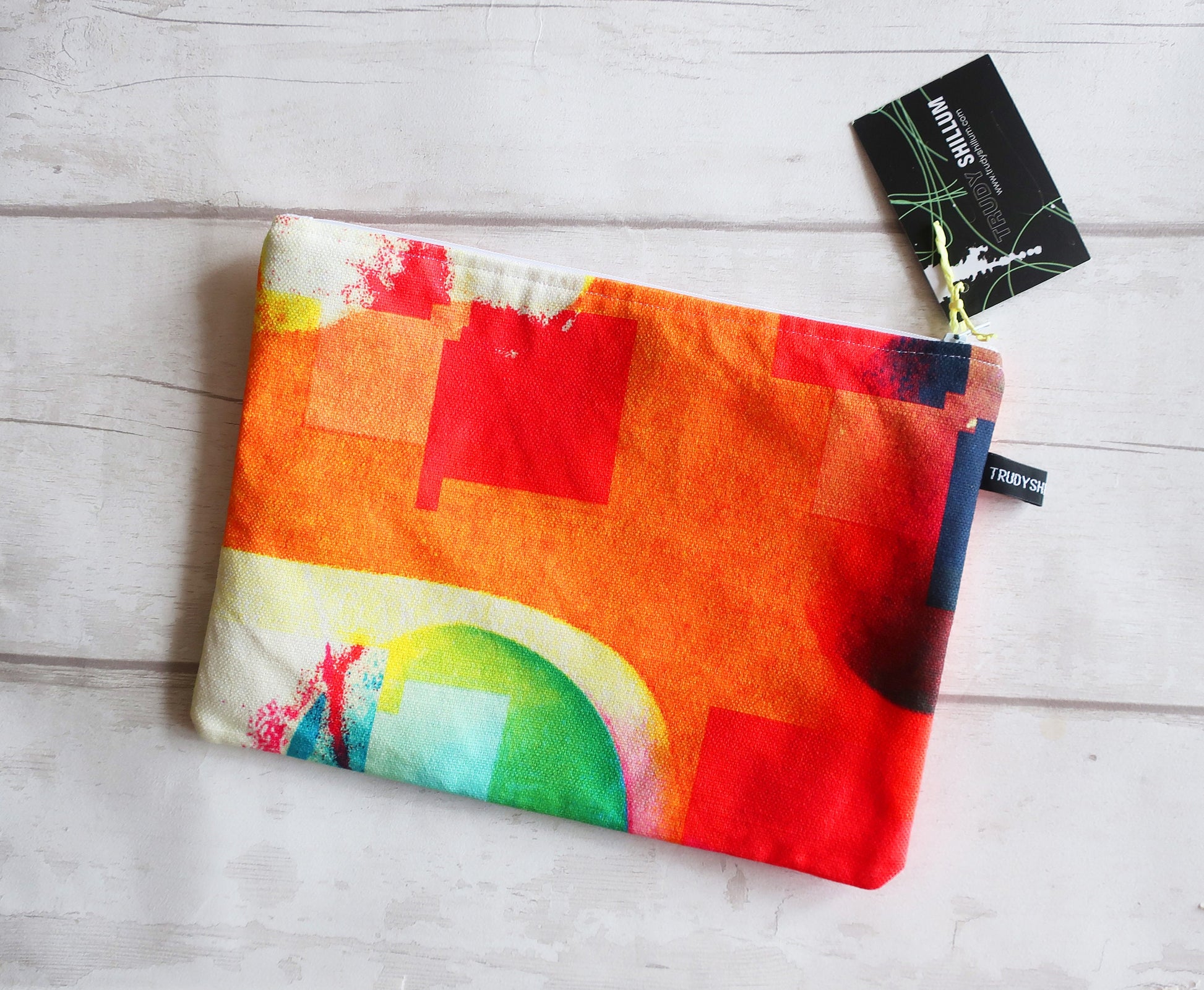 Colorful pouch with abstract design on a light wooden surface