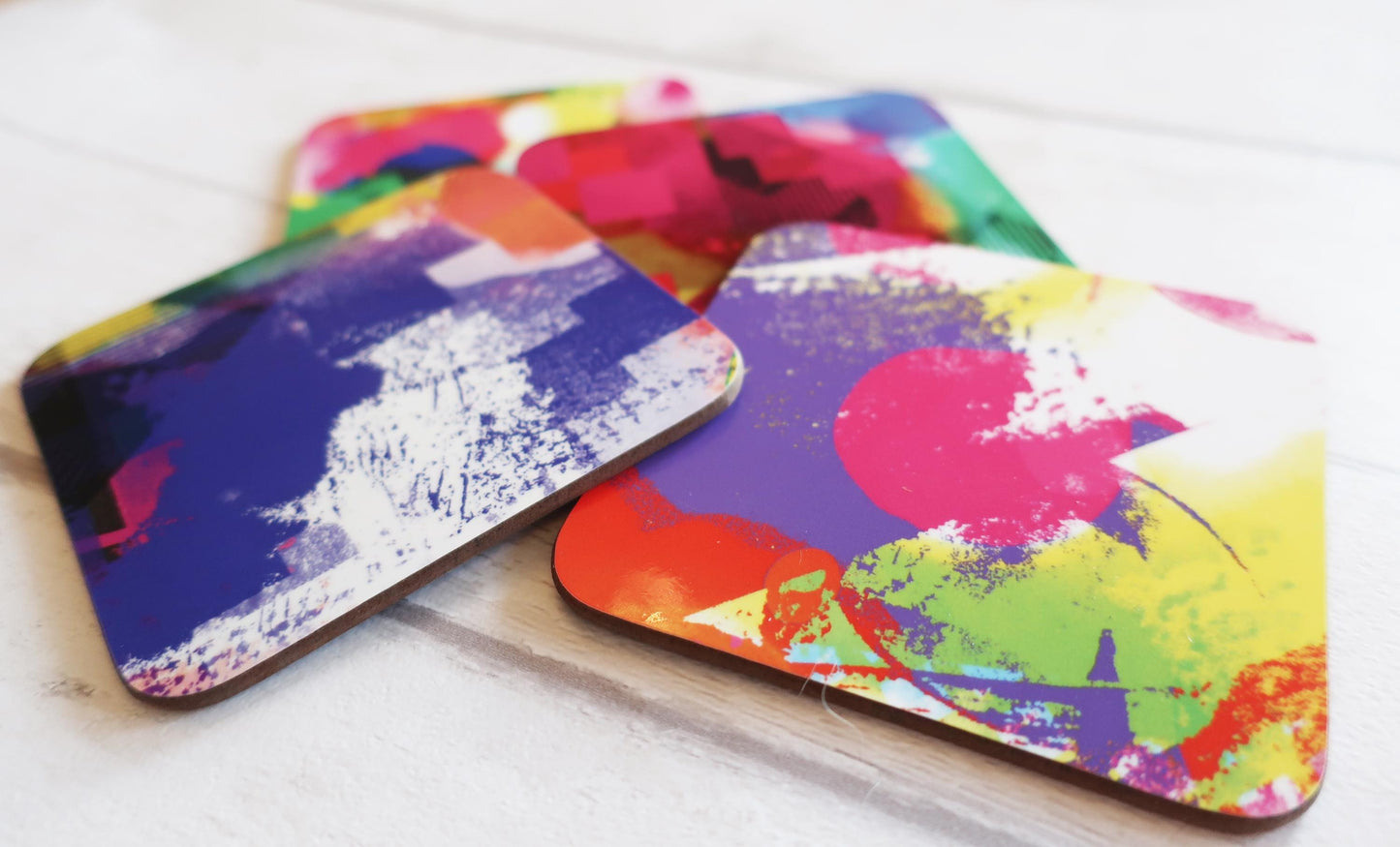Colorful abstract-patterned coasters on a white surface