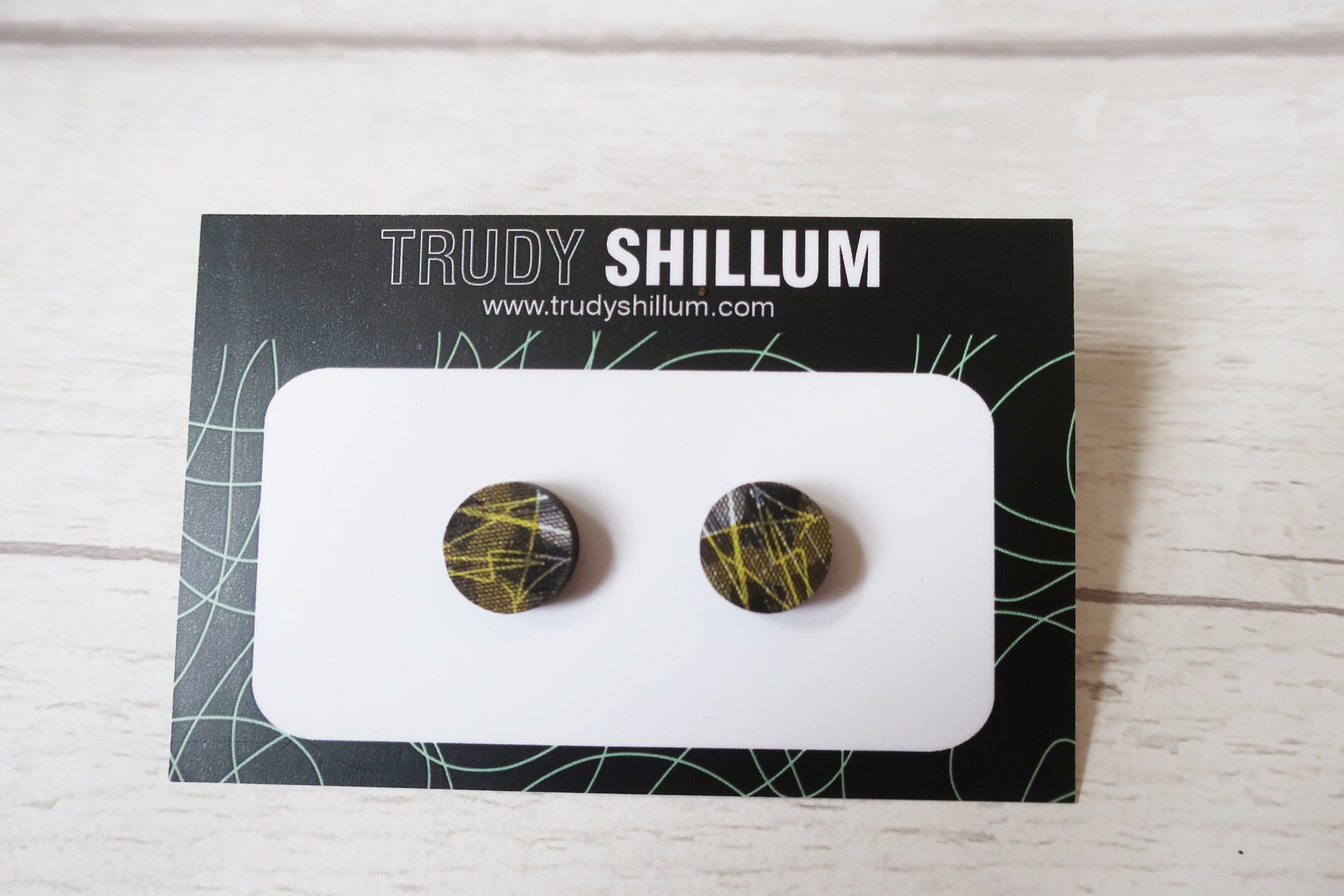 Pair of round earrings on a Trudy Shillum branded card.
