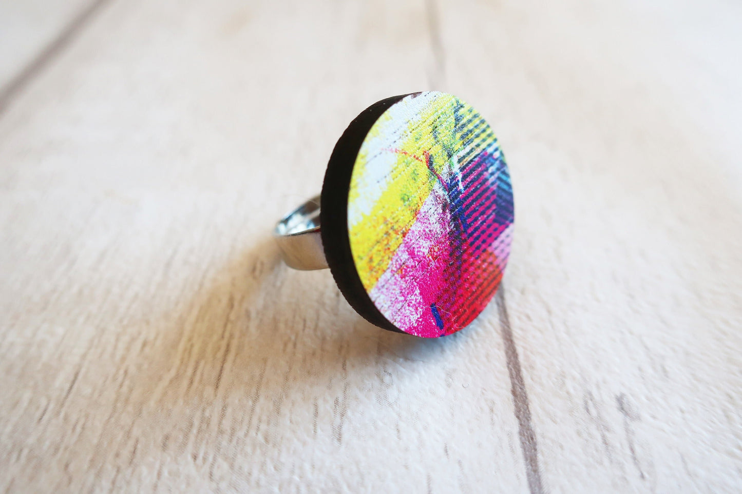 Colorful ring with abstract design on a wooden surface