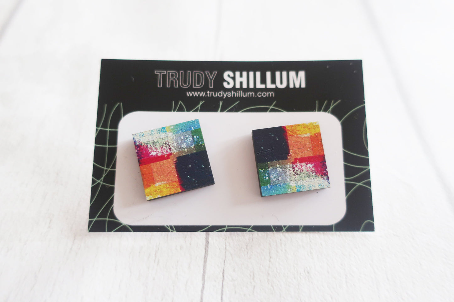 Colorful square earrings on a Trudy Shillum branded card.