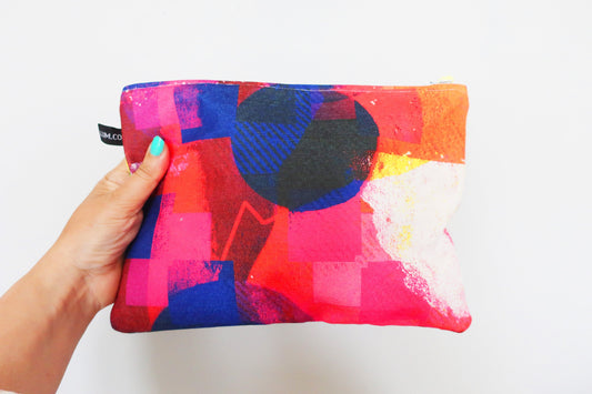 Colorful pouch with abstract design held by a hand on a white background