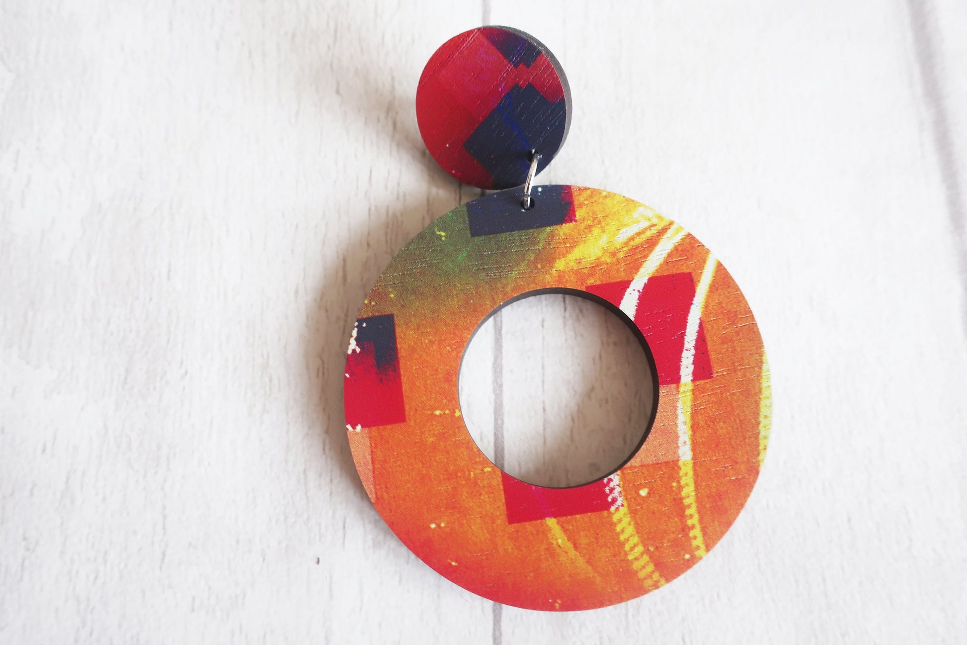 Colorful circular earring with a pattern on a white background
