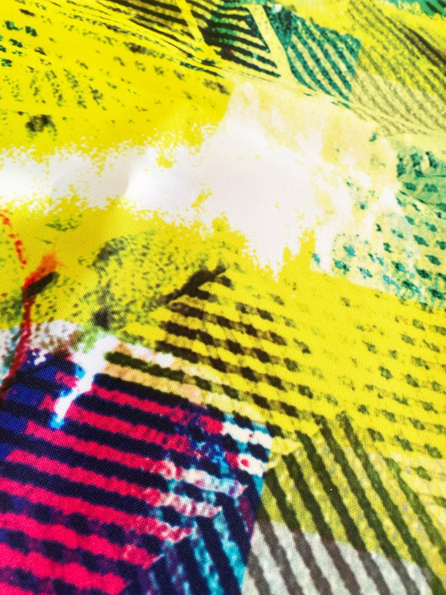 Colorful abstract fabric with a mix of yellow, black, and multicolor patterns.