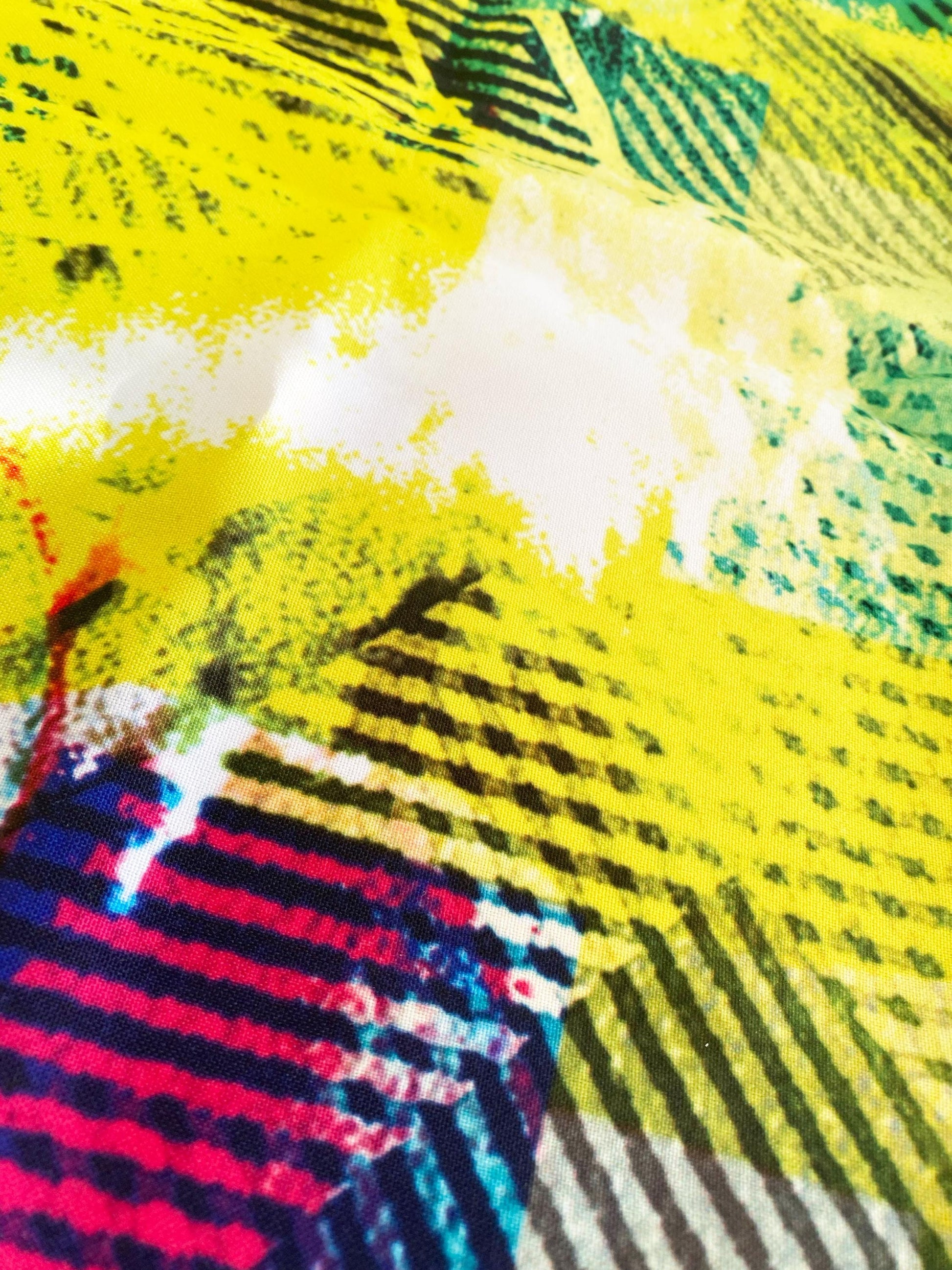 Colorful abstract fabric with a mix of yellow, black, and multicolor patterns.