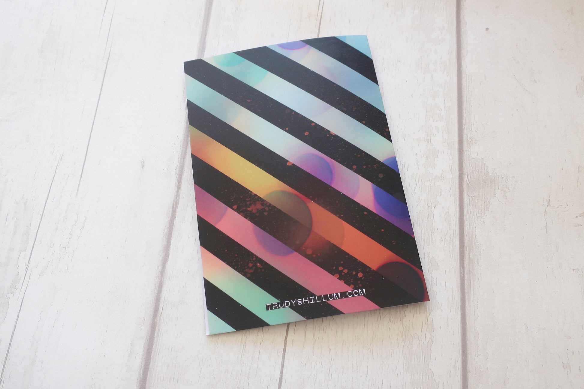 Colorful striped card back on a white wooden surface
