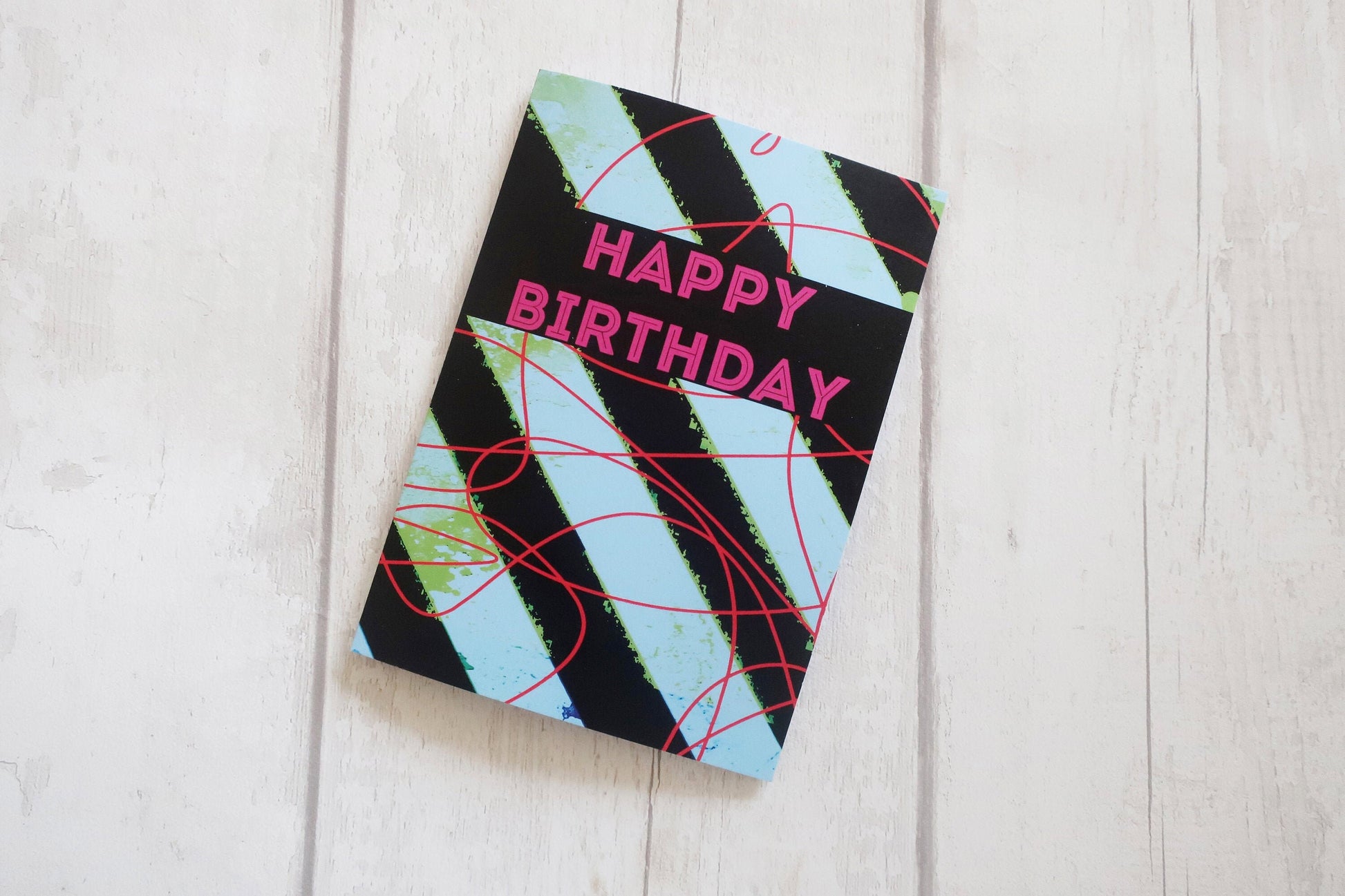 Colorful birthday card with geometric design on a light wooden surface