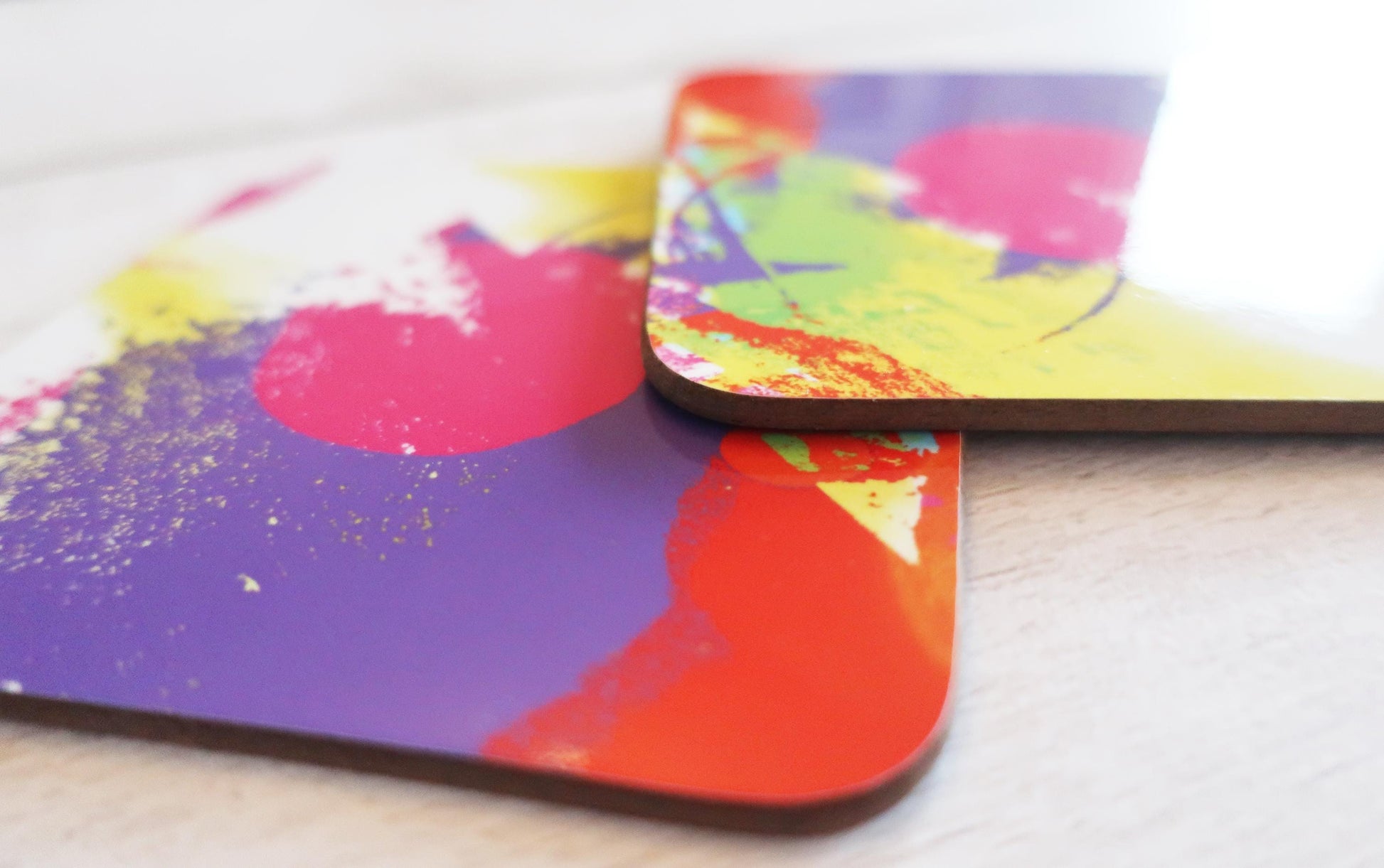 Colorful abstract art coasters on a light surface