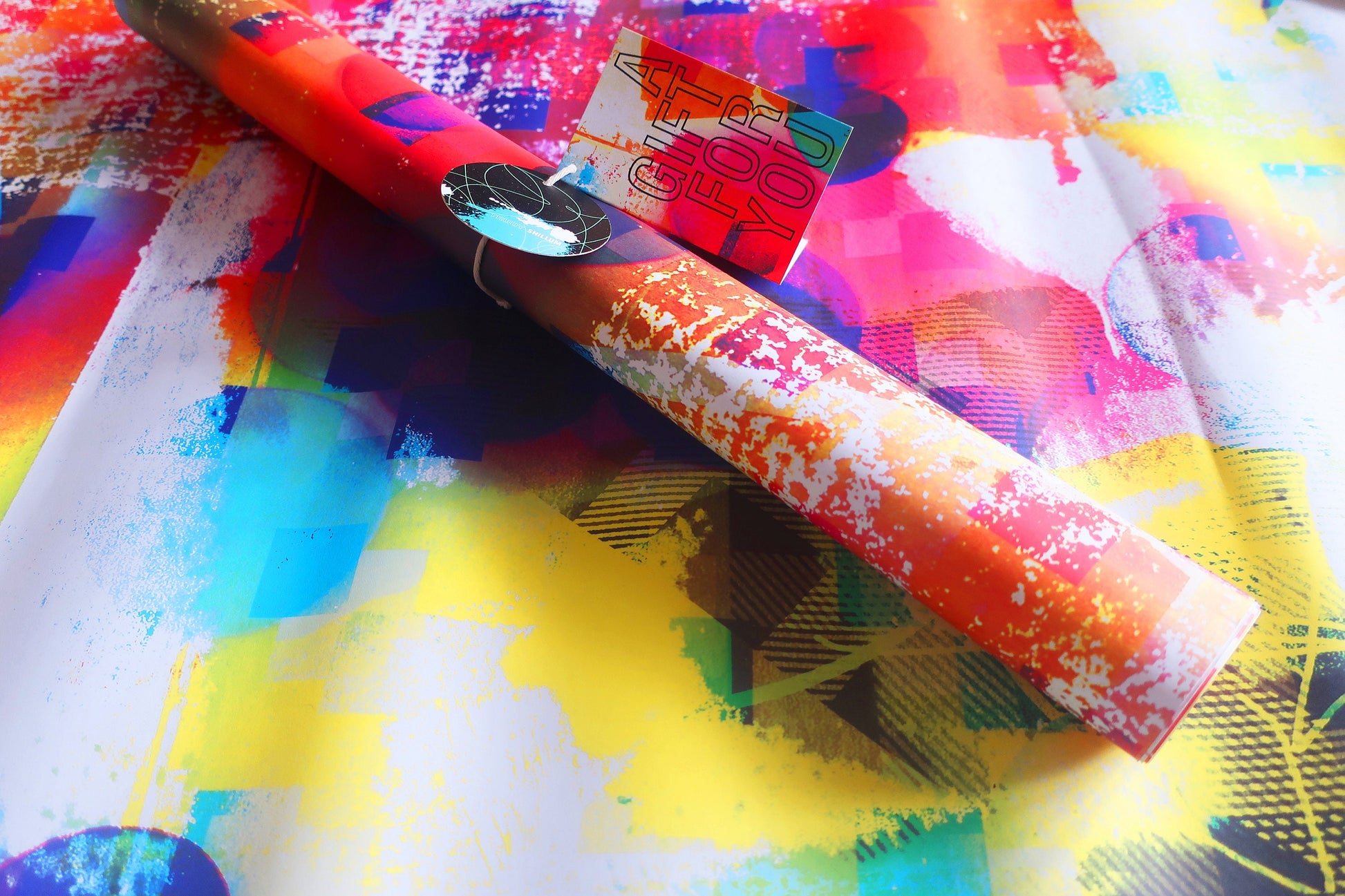 Colorful wrapping paper with a roll of red and white patterned paper on top