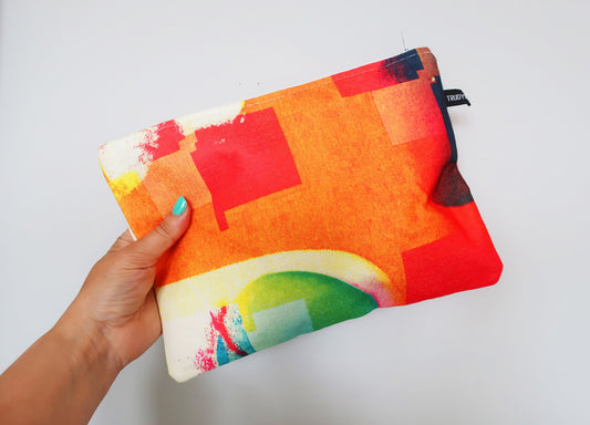 Colorful pouch held by a hand against a white background