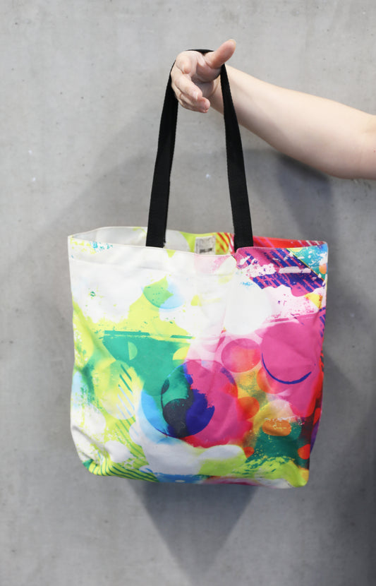 Colourful tote bag being held by Hand