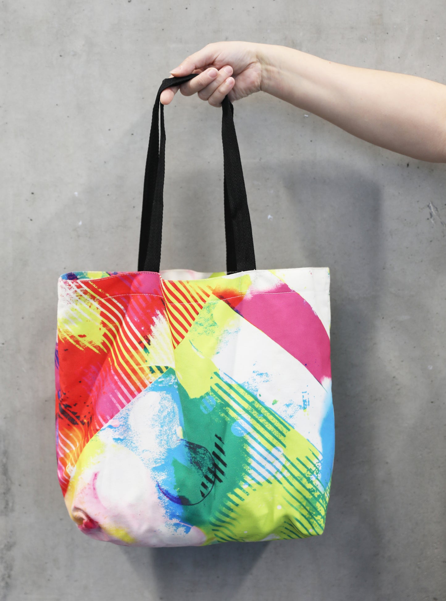Colourful tote bag being held by Hand