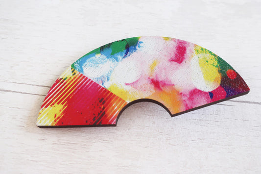 Colorful abstract hairclip on a white wooden surface