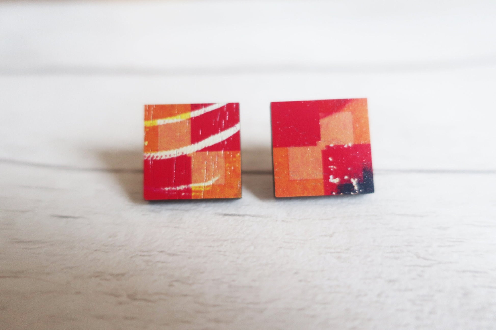 Square earrings with abstract design on a white surface