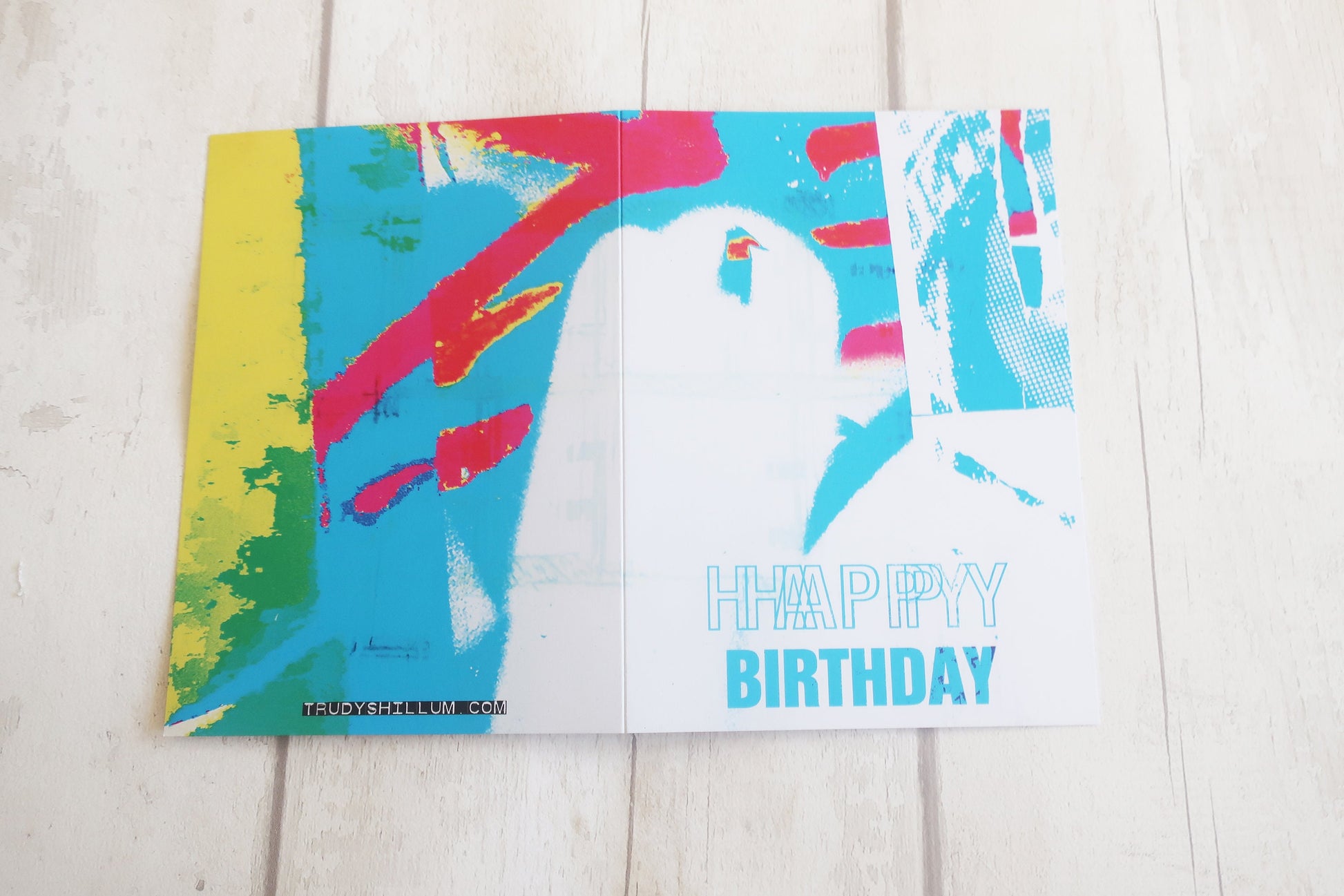 Colorful birthday card with abstract design on a wooden surface