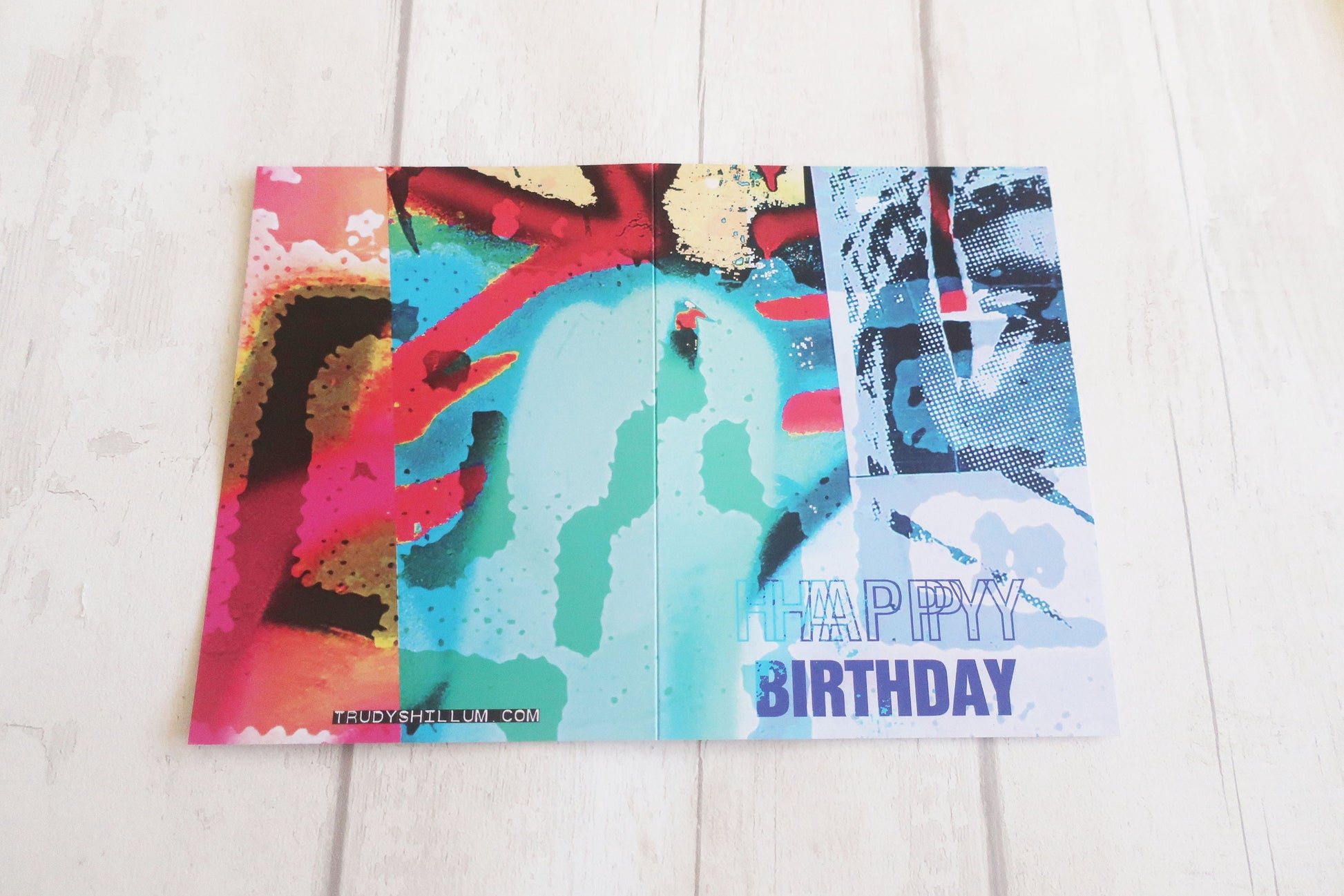 Colorful birthday card with abstract designs on a light wooden surface