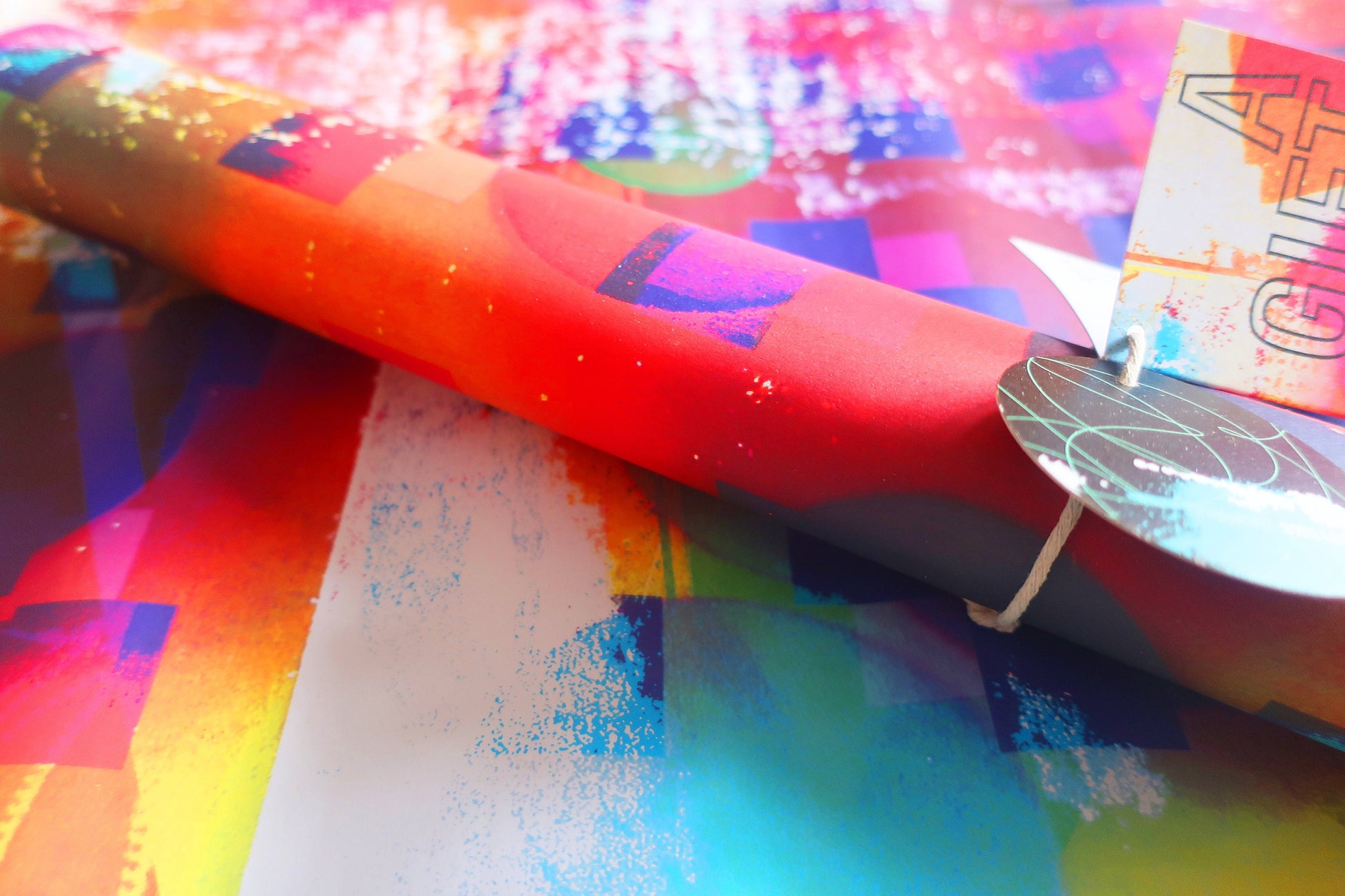 Colorful gift wrap with a bow on a multicolored surface