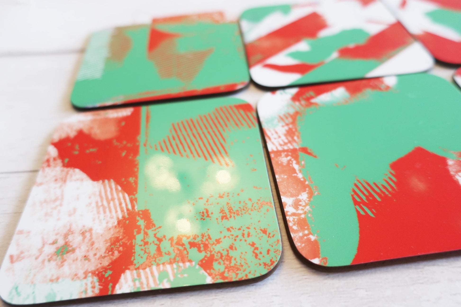 Set of colorful coasters with abstract patterns on a white surface