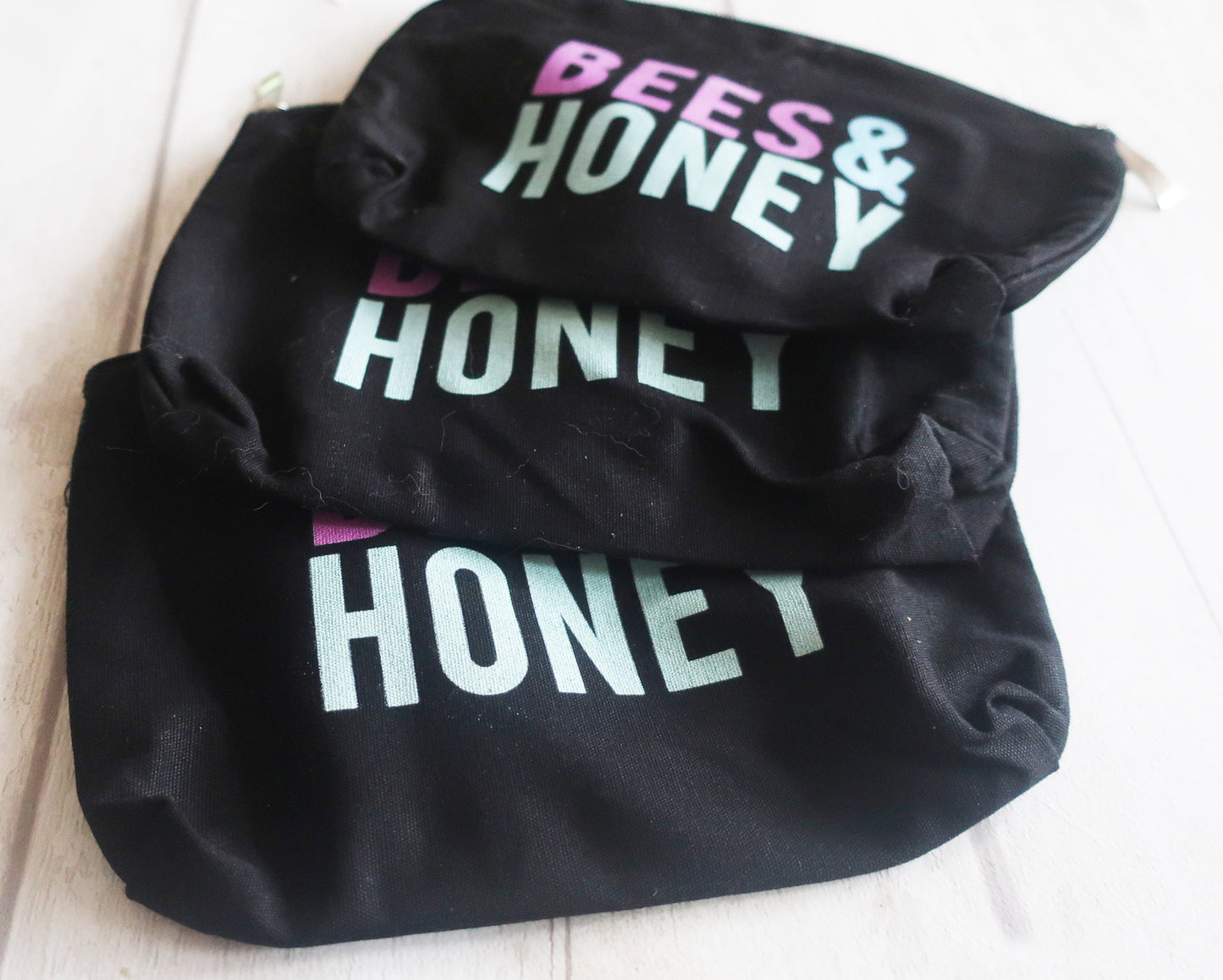 Black bags with 'HONEY' text in different colors on a white background