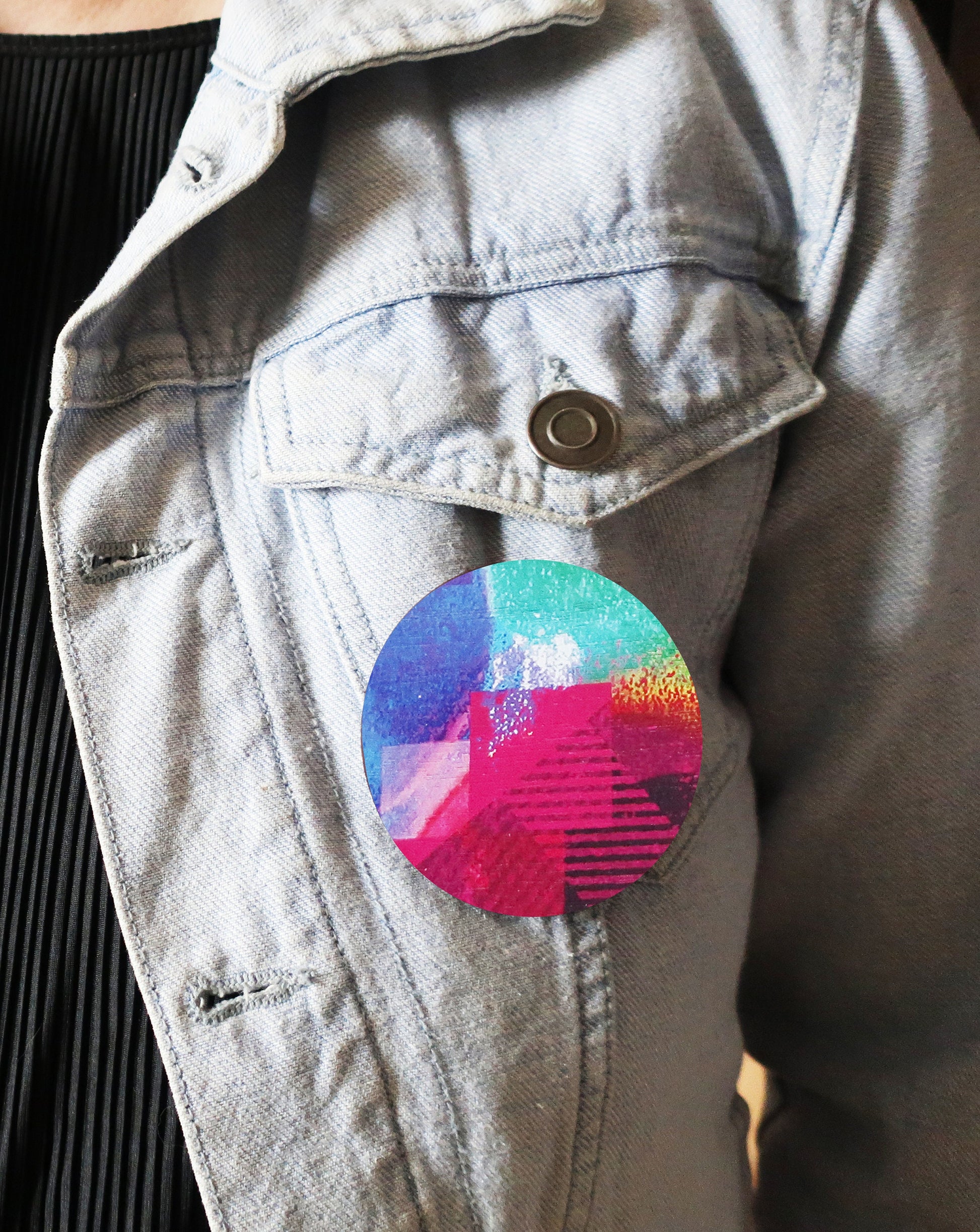 Colorful round brooch on a denim jacket