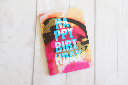 Colorful birthday card with 'Happy Birthday' text on a white wooden surface
