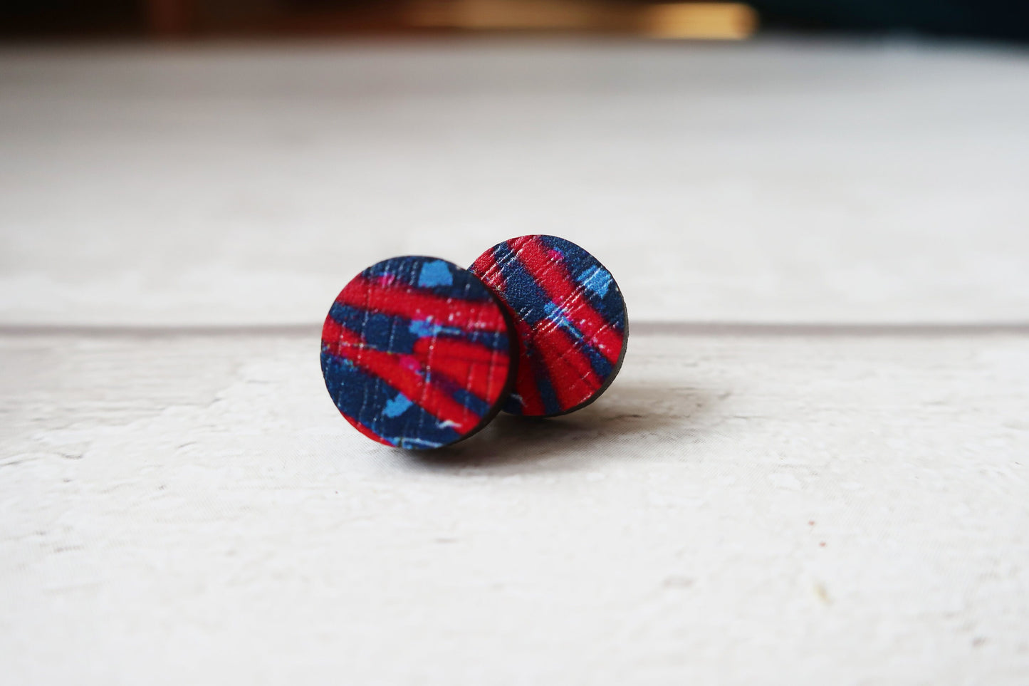 Plaid patterned earrings on a light wooden surface