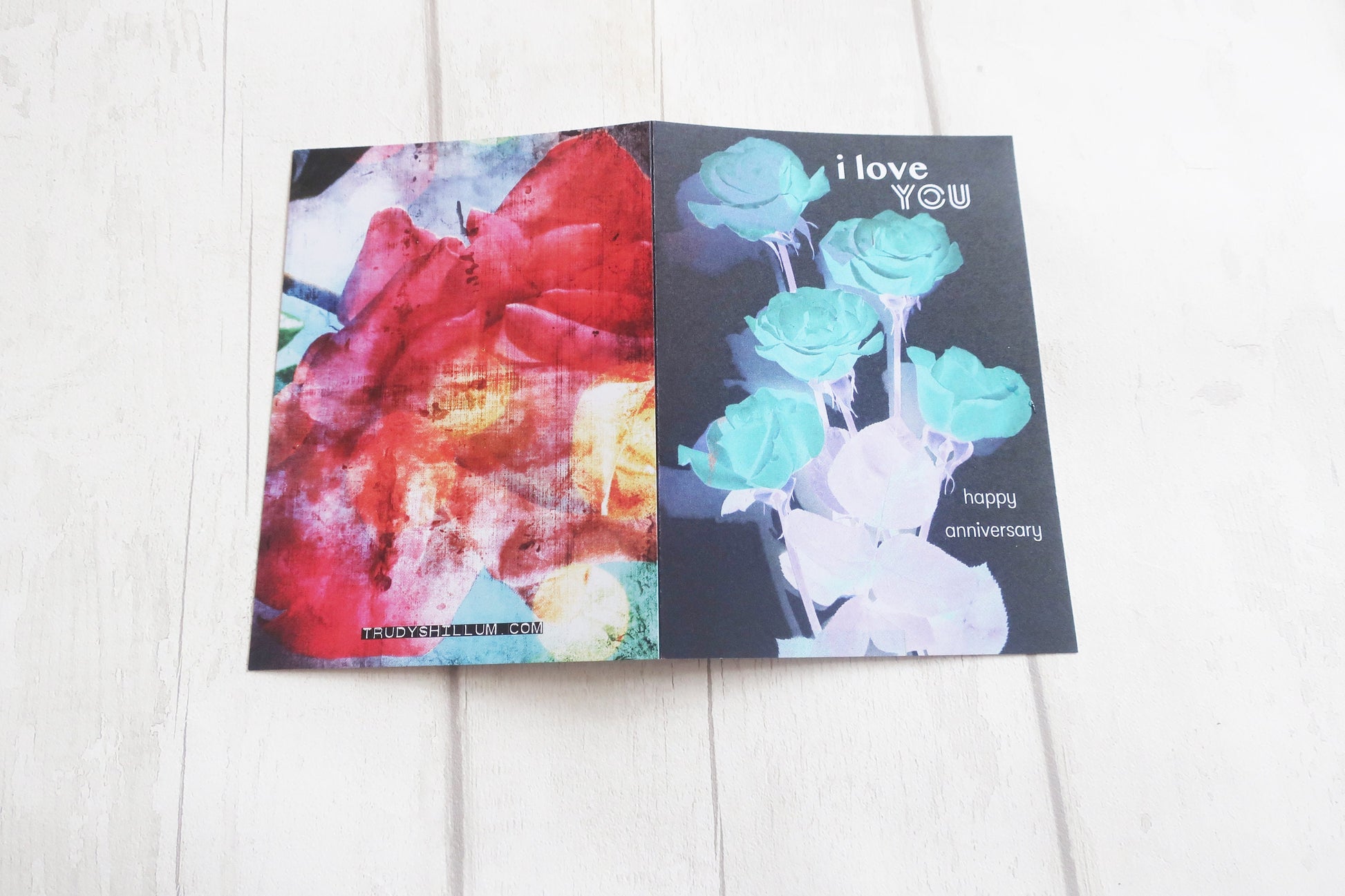 Greeting card with floral design and 'I love you' text on a white wooden surface