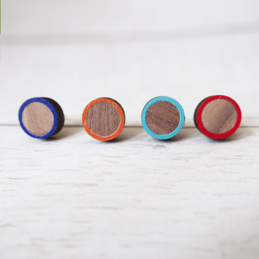 Four round wooden earrings with colorful rims on a white background