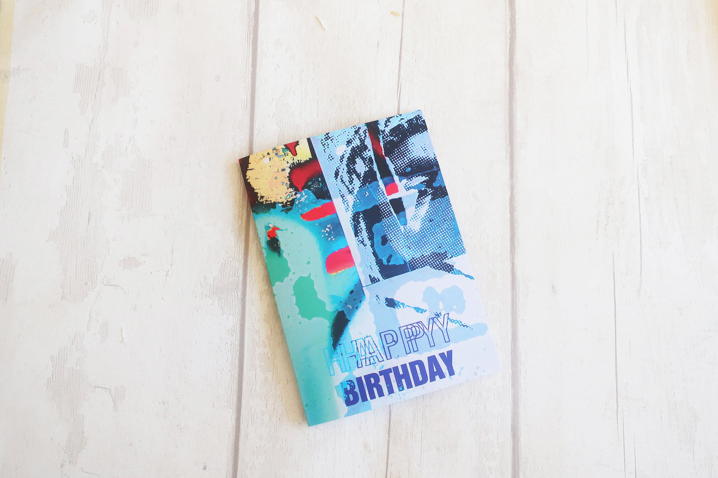 Colorful birthday card with abstract designs on a light wooden surface