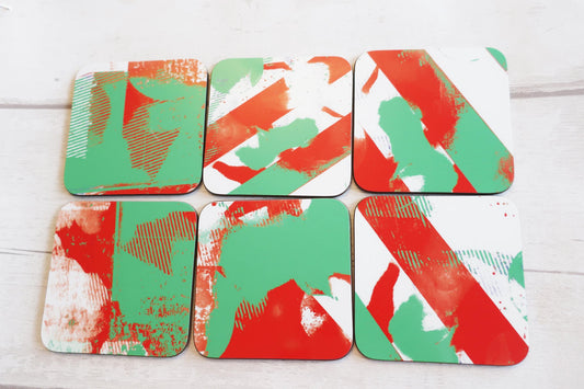 Set of six abstract patterned coasters on a white wooden surface