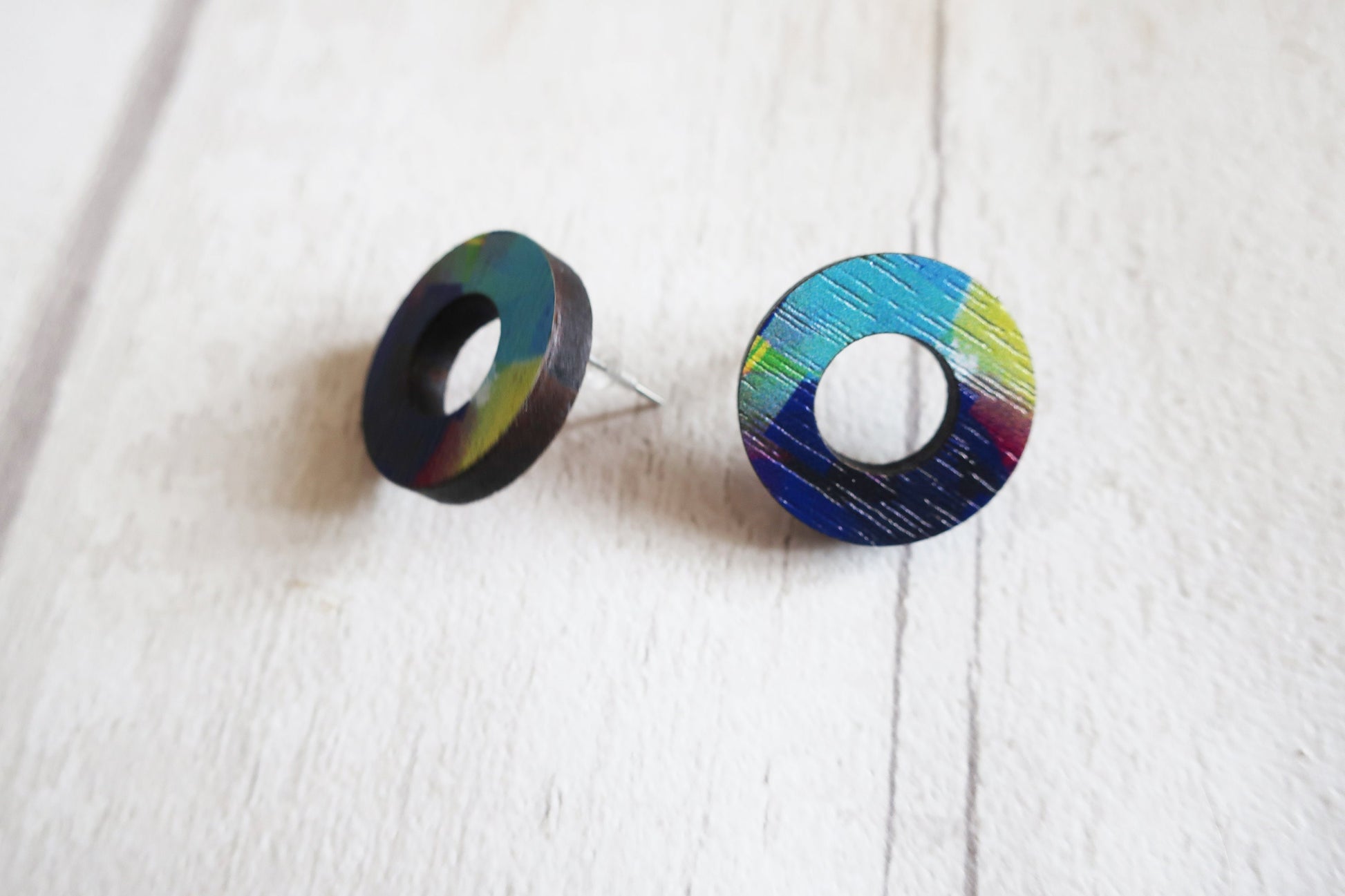 Pair of round earrings with colorful design on a white background