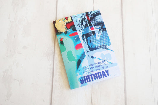 Colorful birthday card with abstract designs on a white wooden surface
