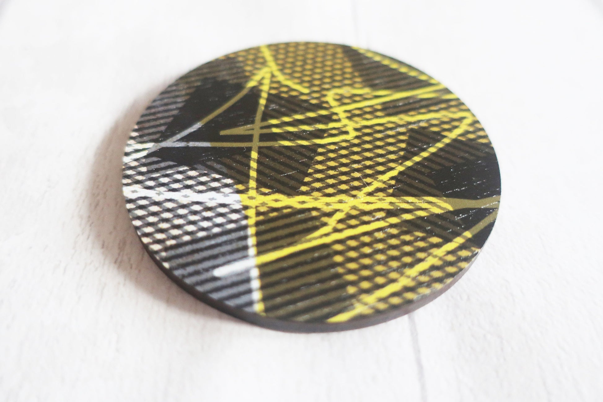 Round brooch with geometric pattern on a white background