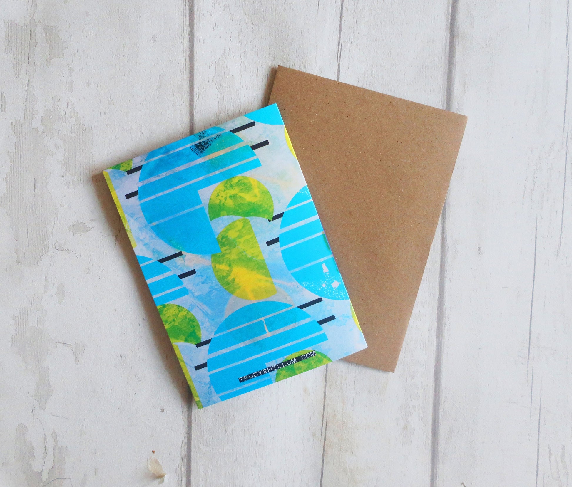 Two notebooks on a wooden surface, one with a blue and green design and the other plain brown.