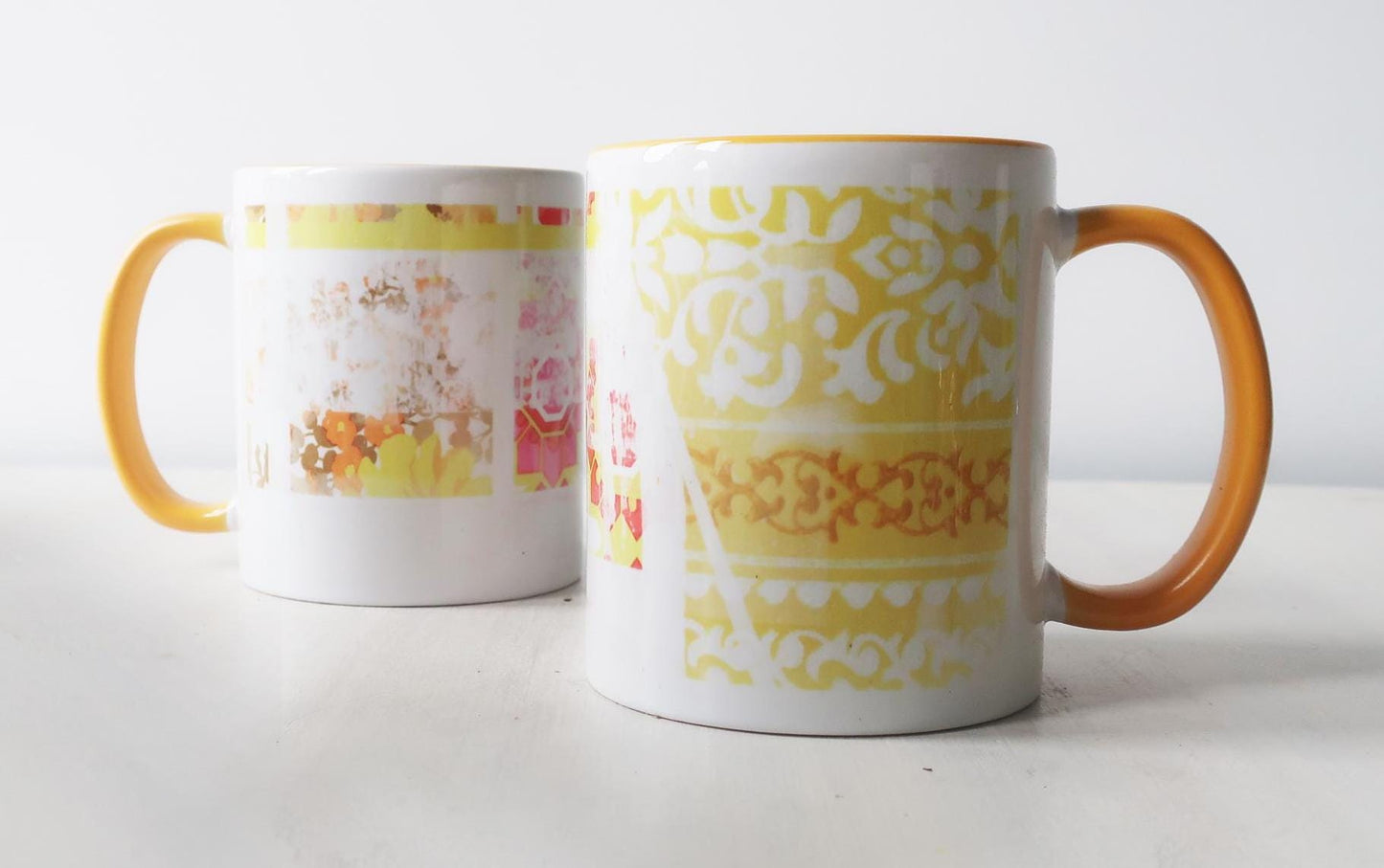 Two mugs with colorful patterns on a white background