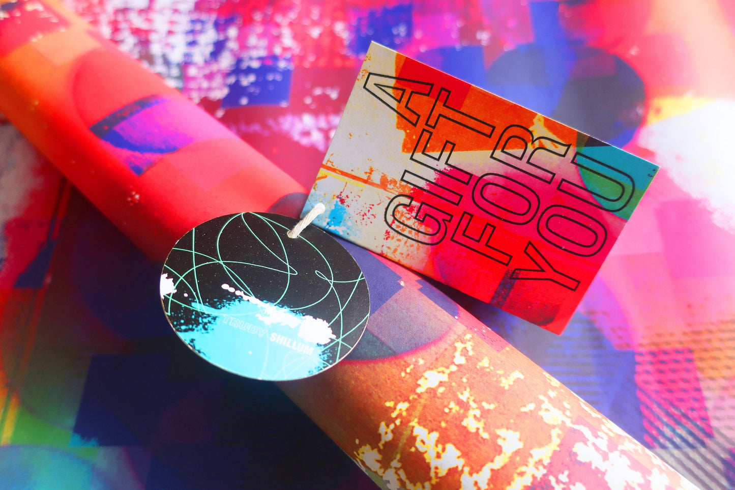 Colorful abstract wrapping paper with text and shapes on a multicolored background