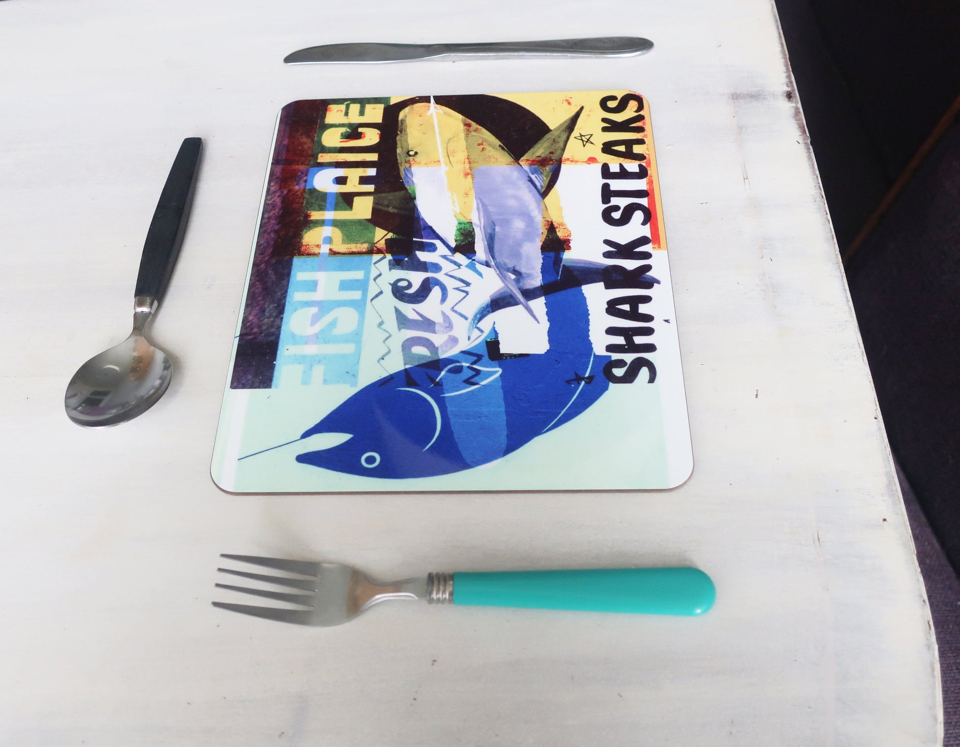 Placemat with shark steak advertisement on a table with cutlery