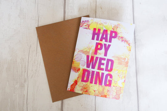 Greeting card with 'Happy Wedding' text on a wooden surface