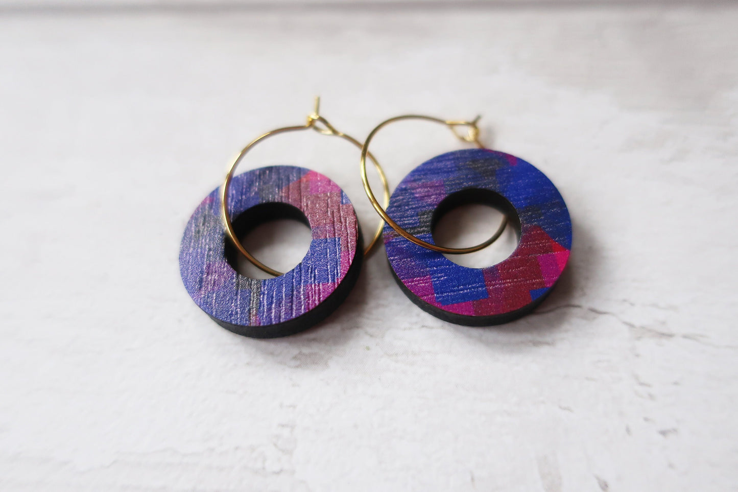 Colorful hoop earrings on a light gray background