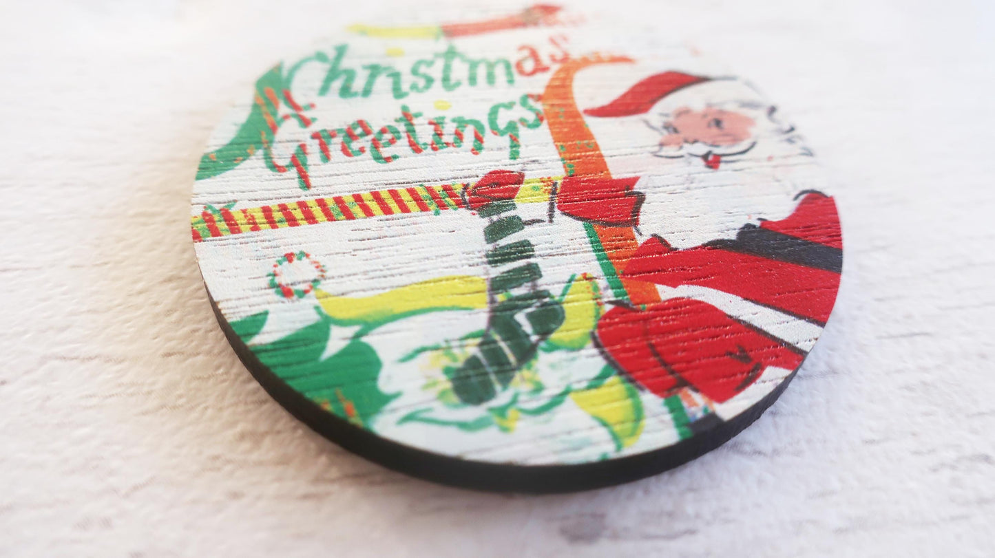 Round Christmas badge with Santa Claus design and 'Christmas Greetings' text on a white background.