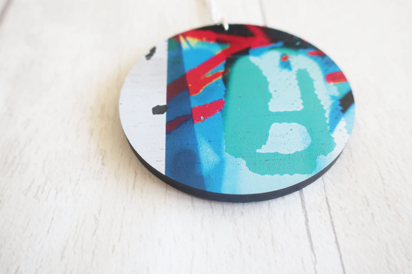 Round colorful necklace with abstract design on a white surface