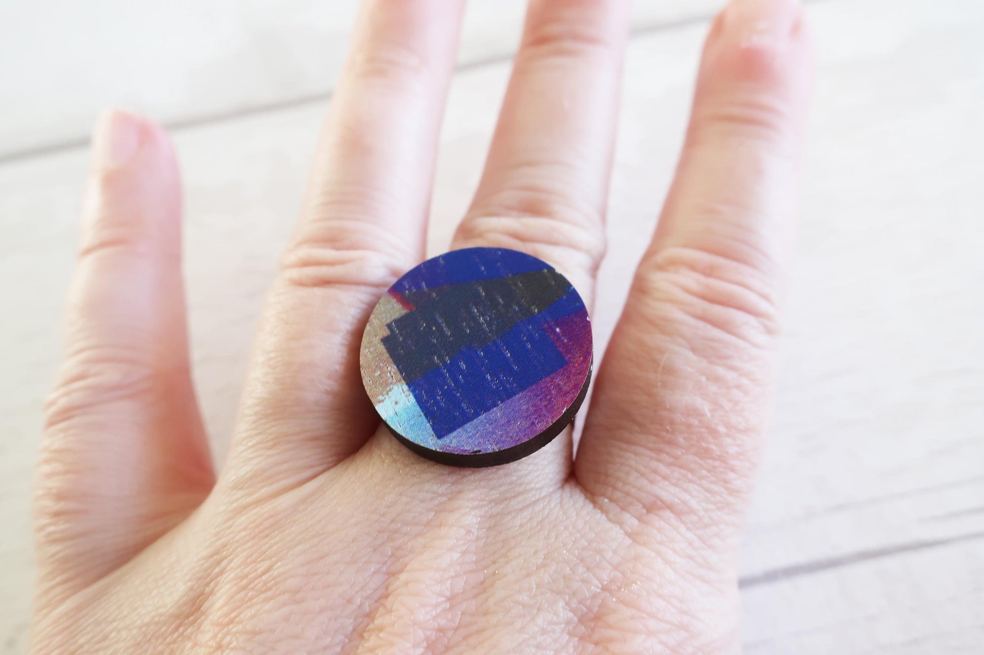 Colorful circular ring held in a hand on a light background