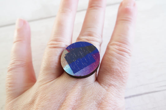 Colorful circular ring held in a hand on a light background