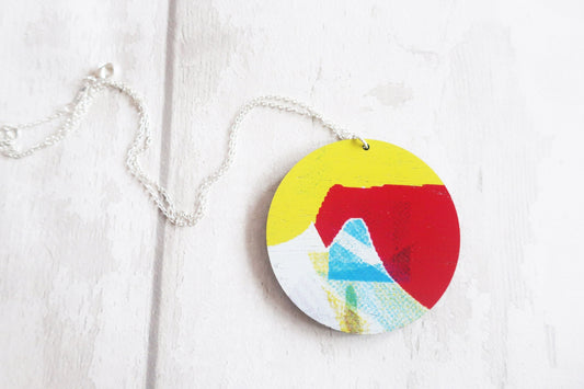 Colorful circular pendant on a chain against a white background