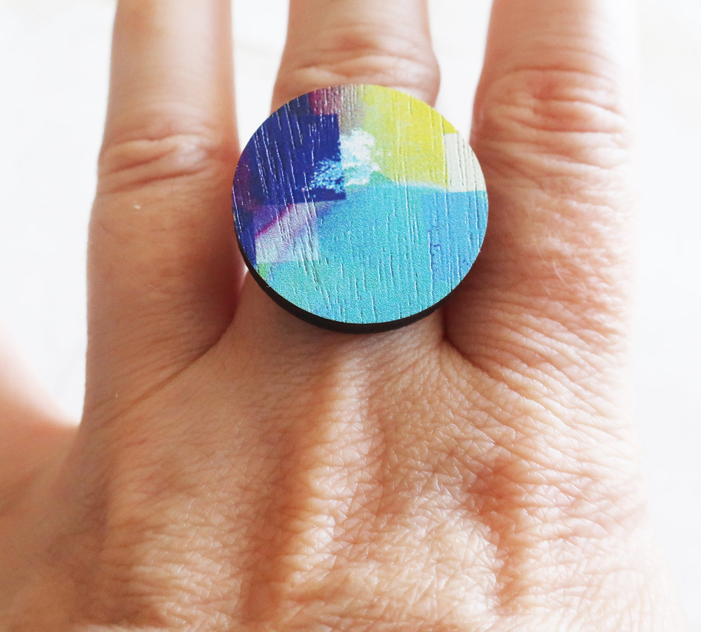 Colorful ring on a finger with a blurred background